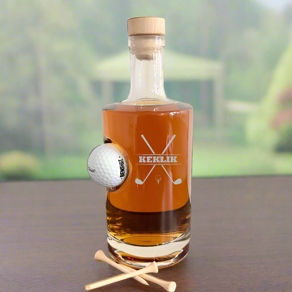 Personalized glass golf decanter with an embedded golf ball, engraved with &quot;KEKLIK&quot; and crossed golf clubs design. 